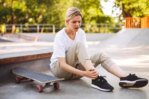 holding-her-painful-Ankle-with-skateboard.webp