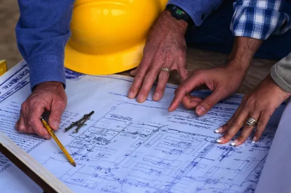 Field workers looking at blueprints