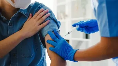 young-asian-lady-nurse-giving-covid-19-flu-antivirus-vaccine-shot-senior-male-patient-(1).webp