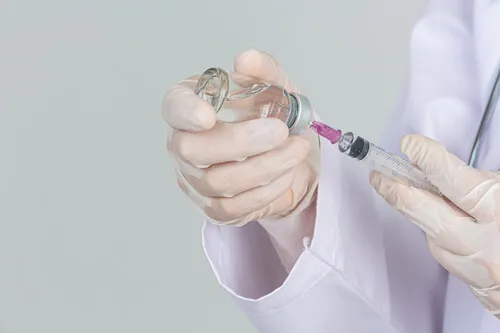 young-doctor-is-holding-hypodermic-syringe-with-vaccine-vial-rubber-gloves-gray-wall.webp